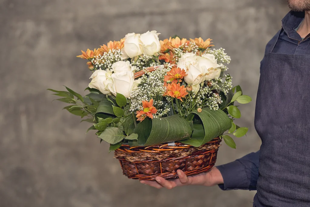 Florista mostrando canasto de flores mixtas.