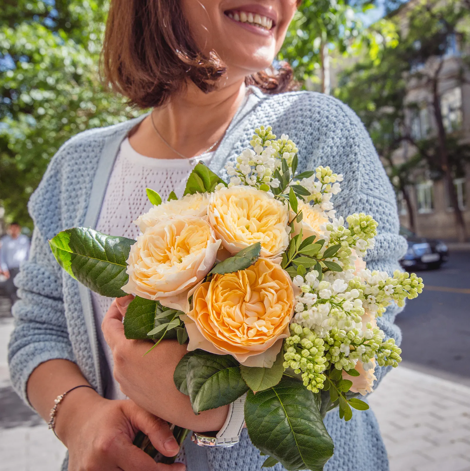 Mujer sosteniendo ramo de flores de temporada.