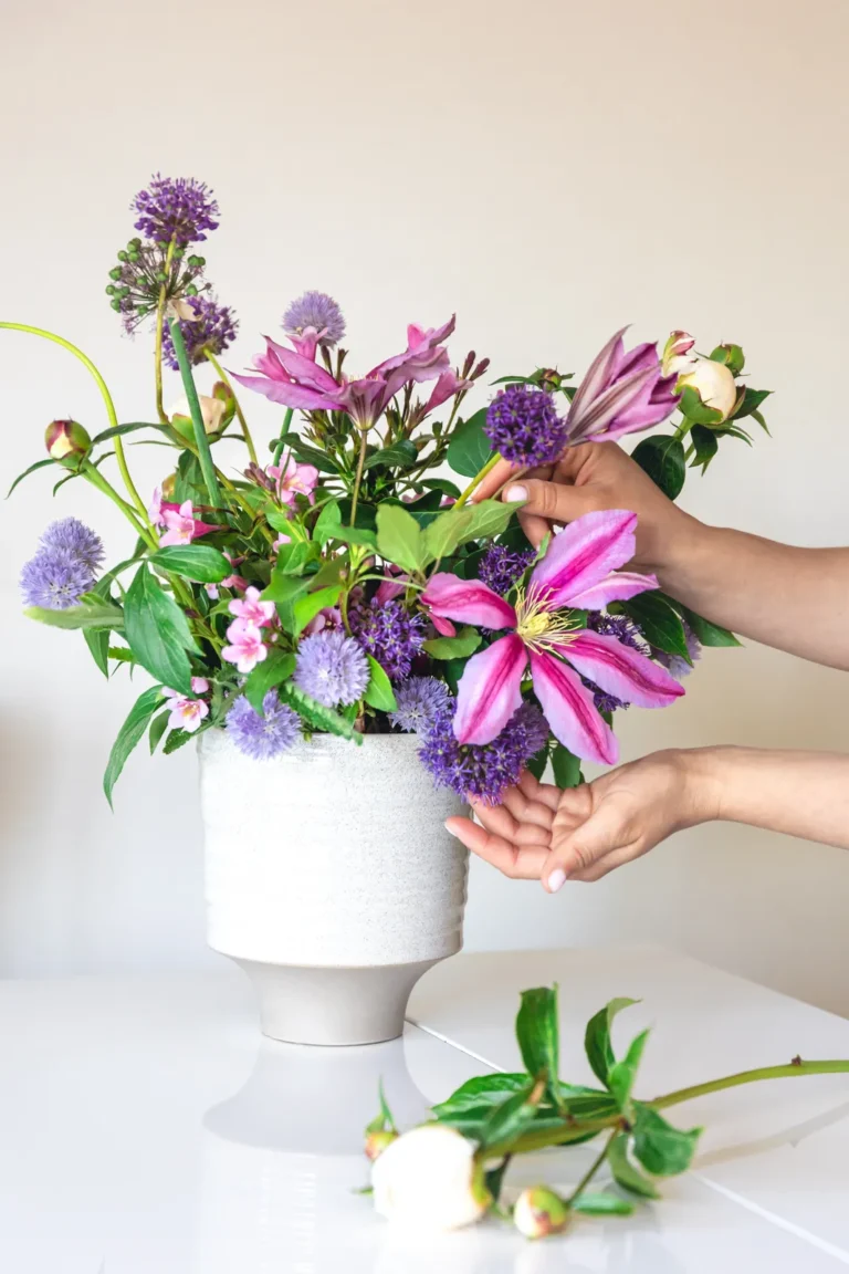 Ramo de flores en manos sobre fondo claro.